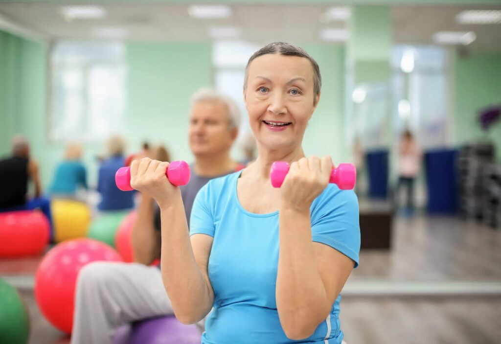 Pegasus Senior Living | Seniors participating in group exercises with small light weights
